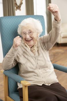 Senior Woman Celebrating In Chair At Home