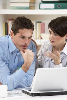 Worried Couple Working From Home Using Laptop