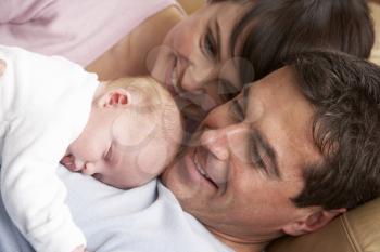 Portrait Of Proud Parents With Newborn Baby At Home