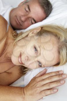 Mid age couple in bed woman awake