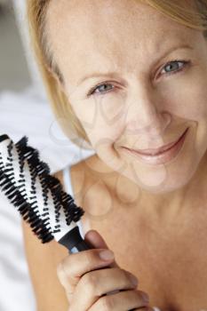 Mid age woman holding hairbrush