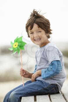 Young boy holding windmill into the wind
