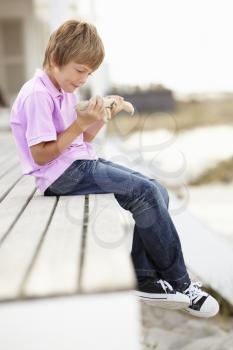 Young boy outdoors holding starfish