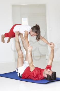 Father and daughter doing yoga lift
