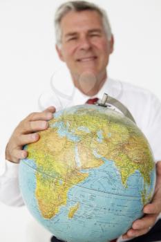 Senior businessman holding globe