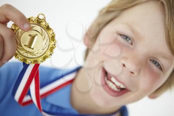 Young boy showing off medal