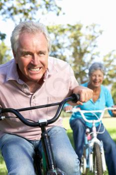 Senior couple playing on children's bikes