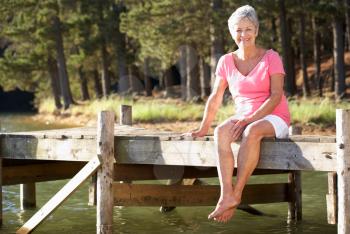 Senior woman sitting by lake