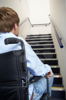 Man in wheelchair at foot of stairs