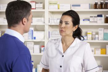 American pharmacist talking to man in pharmacy