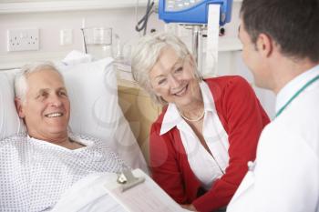 Doctor talking to senior couple on USA Hospital ward