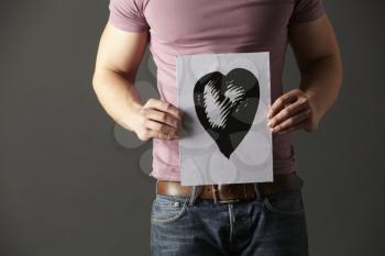 Man holding ink drawing of heart