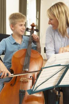 Boy playing cello in music lesson