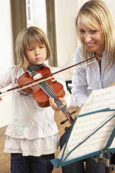 Young girl playing violin in music lesson