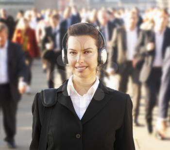 Female commuter in crowd wearing headphones