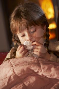 Sick Girl With Cold Resting On Sofa By Cosy Log Fire