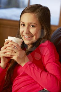 Teenage Girl Relaxing On Sofa With Hot Drink