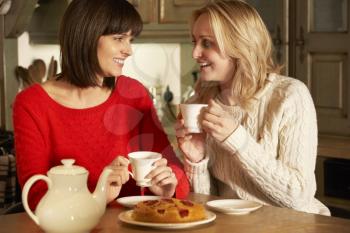 Two Middle Aged Women Enjoying Tea And Cake Together