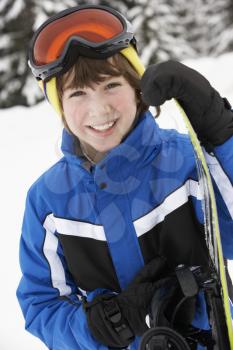 Young Boy With Snowboard On Ski Holiday In Mountains