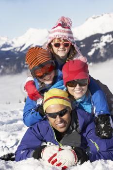 Family Having Fun On Ski Holiday In Mountains