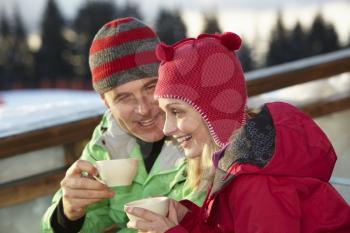 Couple Enjoying Hot Drink In Caf At Ski Resort