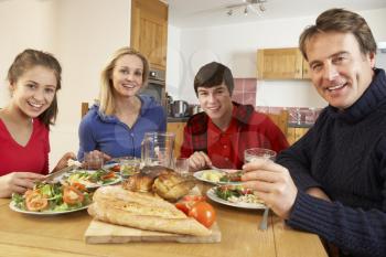 Teenage Family Eating Lunch Together In Kitchen