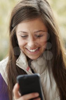 Teenage Girl Texting On Smartphone Wearing Winter Clothes