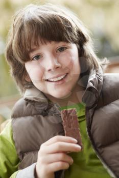 Boy Eating Chocolate Bar Wearing Winter Clothes