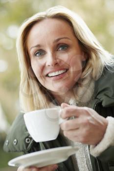 Woman In Outdoor Caf With Hot Drink  Wearing Winter Clothes