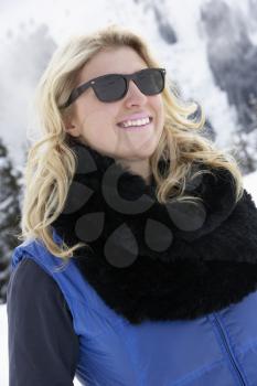 Young Woman On Ski Holiday In Mountains