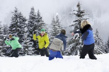 Group Of Young Friends Having Snowball Fight On Ski Holiday In Mountains