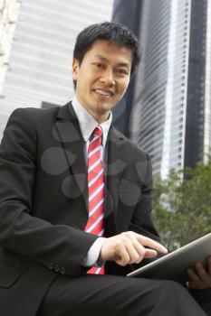 Chinese Businessman Working On Tablet Computer Outside Office