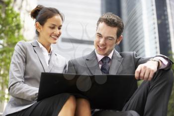 Businessman And Businesswoman Discussing Document Outside Office
