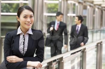 Portrait Of Chinese Businesswoman Outside Office With Colleagues In Background