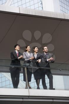 Four Business Colleagues Having Discussion Outside Office Building