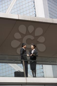 Two Business Colleagues Having Discussion Outside Office Building