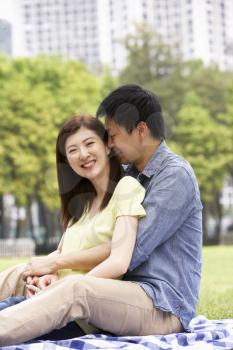 Young Chinese Couple Relaxing In Park Together