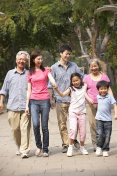 Portrait Of Multi-Generation Chinese Family Walking In Park Together