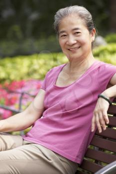Senior Chinese Woman Relaxing On Park Bench