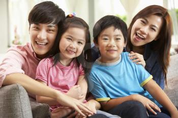 Chinese Family Relaxing On Sofa At Home