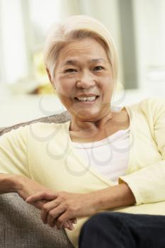 Senior Chinese Woman Relaxing On Sofa At Home