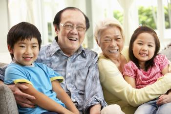 Portrait Of Chinese Grandparents With Grandchildren Relaxing At Home Together
