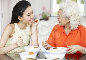 Chinese Mother And Adult Daughter Eating Meal Together