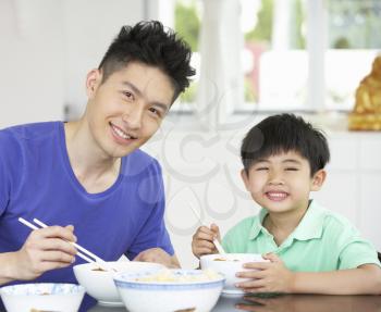 Chinese Father And Son Sitting At Home Eating A Meal