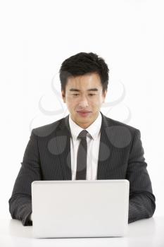 Studio Shot Of Chinese Businessman Working On Laptop