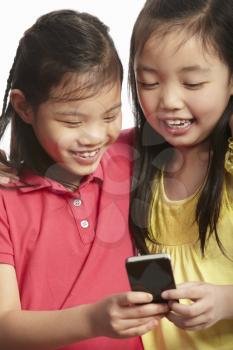 Studio Shot Of  Two Chinese Girls With Mobile Phone