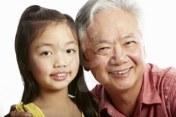 Studio Shot Of Chinese Grandfather With Granddaughter