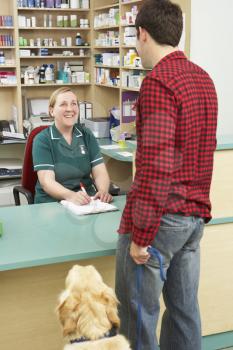 Man Making Appointment At Reception Of Veterinary Surgery