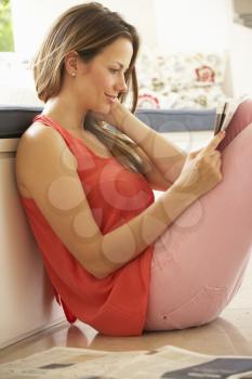 Woman Relaxing With Newspaper At Home