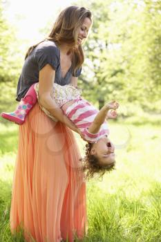 Mother Playing With Young Daughter In Summer Field